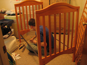 Charlie sits imprisoned while assembling the crib